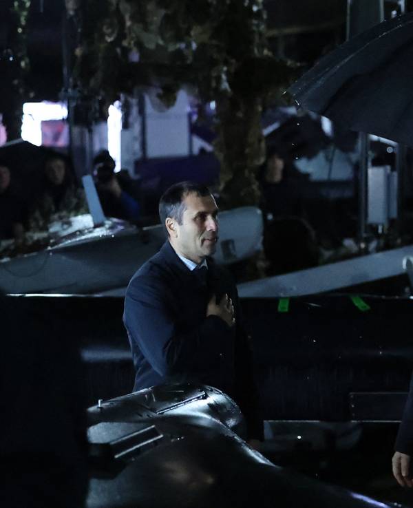 Der russische Präsident Wladimir Putin (rechts) hält einen Regenschirm in der Hand, während er am 2. Oktober 2026 bei einem Besuch eines Truppenübungsplatzes in der Region Tscheljabinsk im Regen steht.