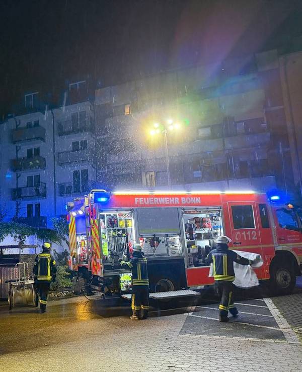 Einsatzkräfte der Feuerwehr stehen vor dem betroffenen Wohnheim in der Bonner Nordstadt.