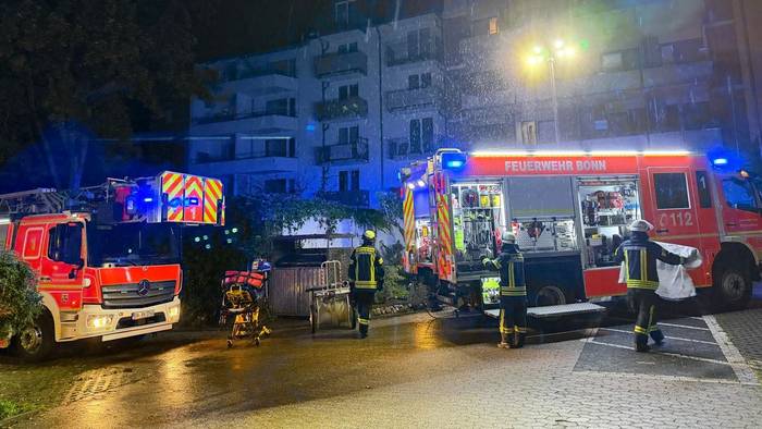 Einsatzkräfte der Feuerwehr stehen vor dem betroffenen Wohnheim in der Bonner Nordstadt.