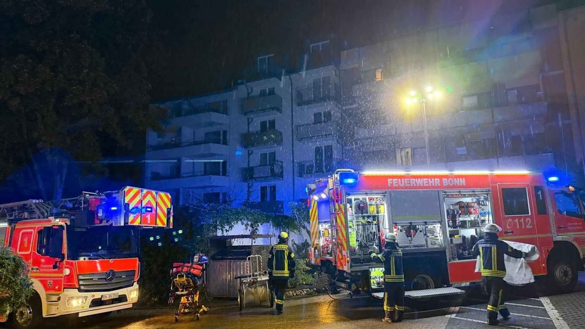 Einsatzkräfte der Feuerwehr stehen vor dem betroffenen Wohnheim in der Bonner Nordstadt.