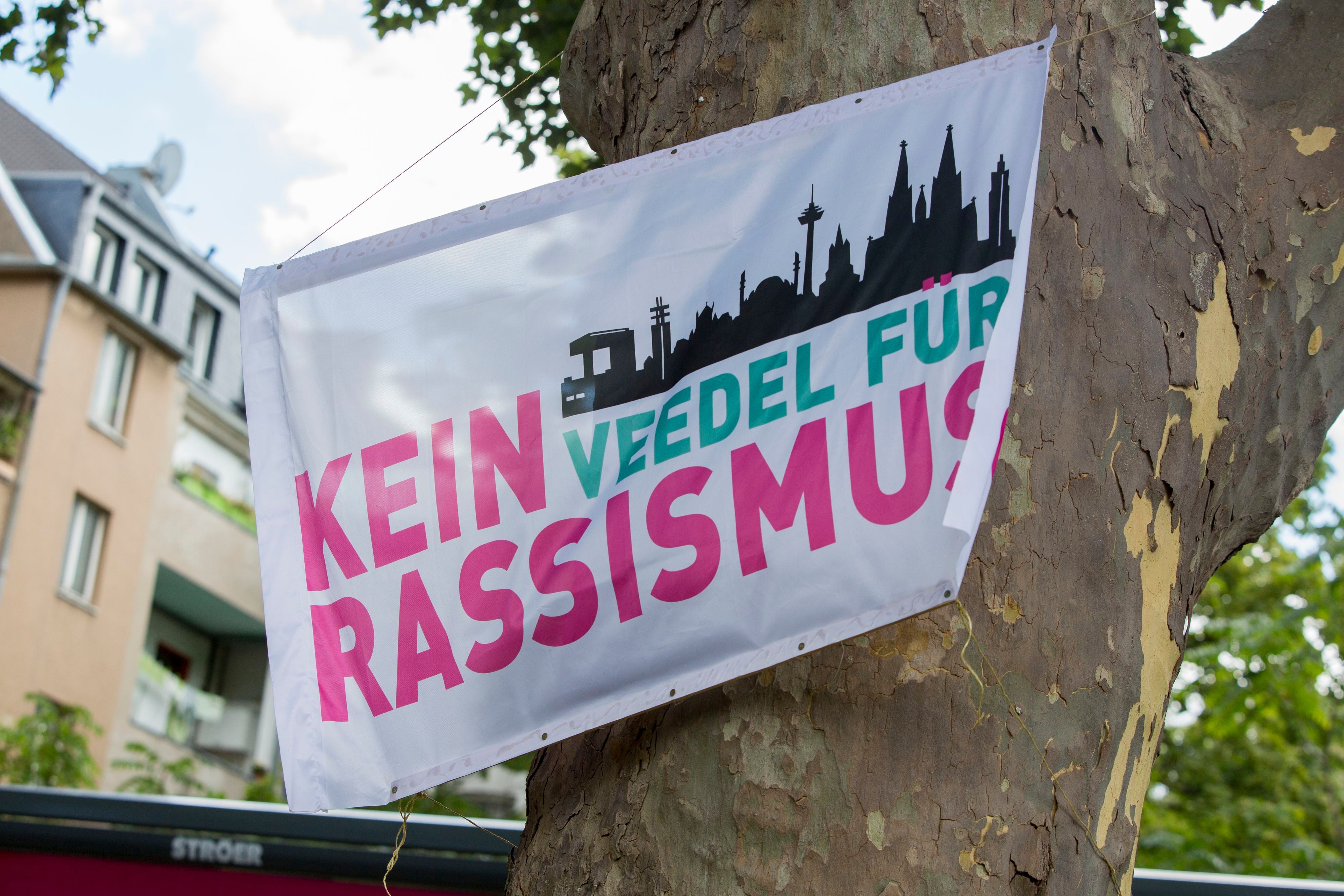 Menschen mit Fahnen der Initiative „Kein Veedel für Rassismus“ positionierten sich spontan in Sichtweite des AfD-infostandes. (Symbolfoto)