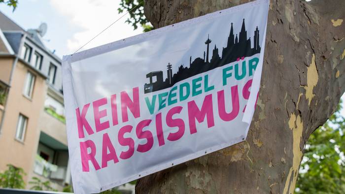 Menschen mit Fahnen der Initiative „Kein Veedel für Rassismus“ positionierten sich spontan in Sichtweite des AfD-infostandes. (Symbolfoto)