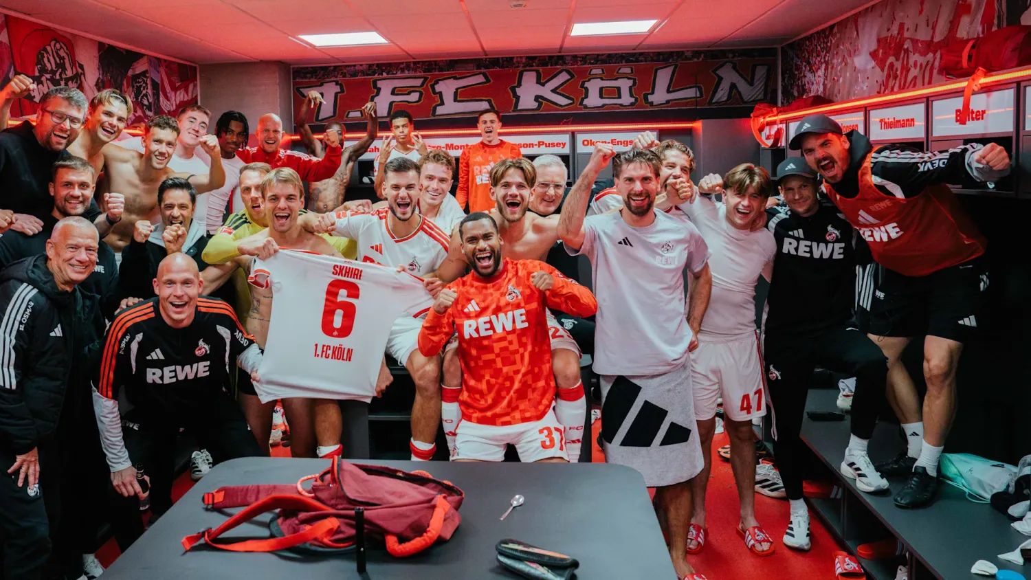Die FC-Profis jubeln nach dem Derbysieg gegen Gladbach in der Kabine mit einem Trikot von Ellyes Skhiri.