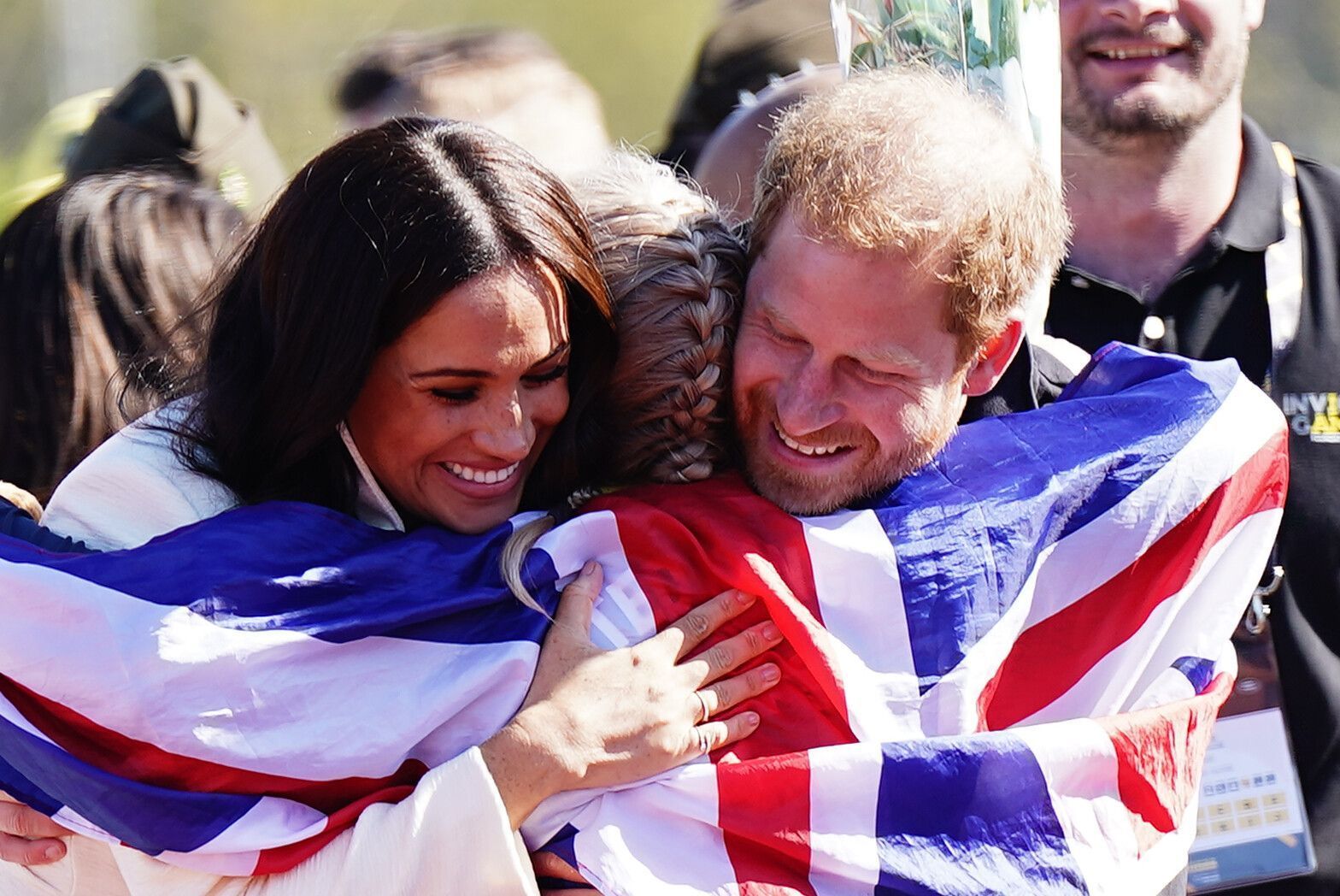 Prinz Harry (r), Herzog von Sussex, und Meghan (l), Herzogin von Sussex, umarmen die britische Teilnehmerin Lisa Johnston während der Leichtathletikwettbewerbe der Invictus Games 2022 im Zuiderpark.