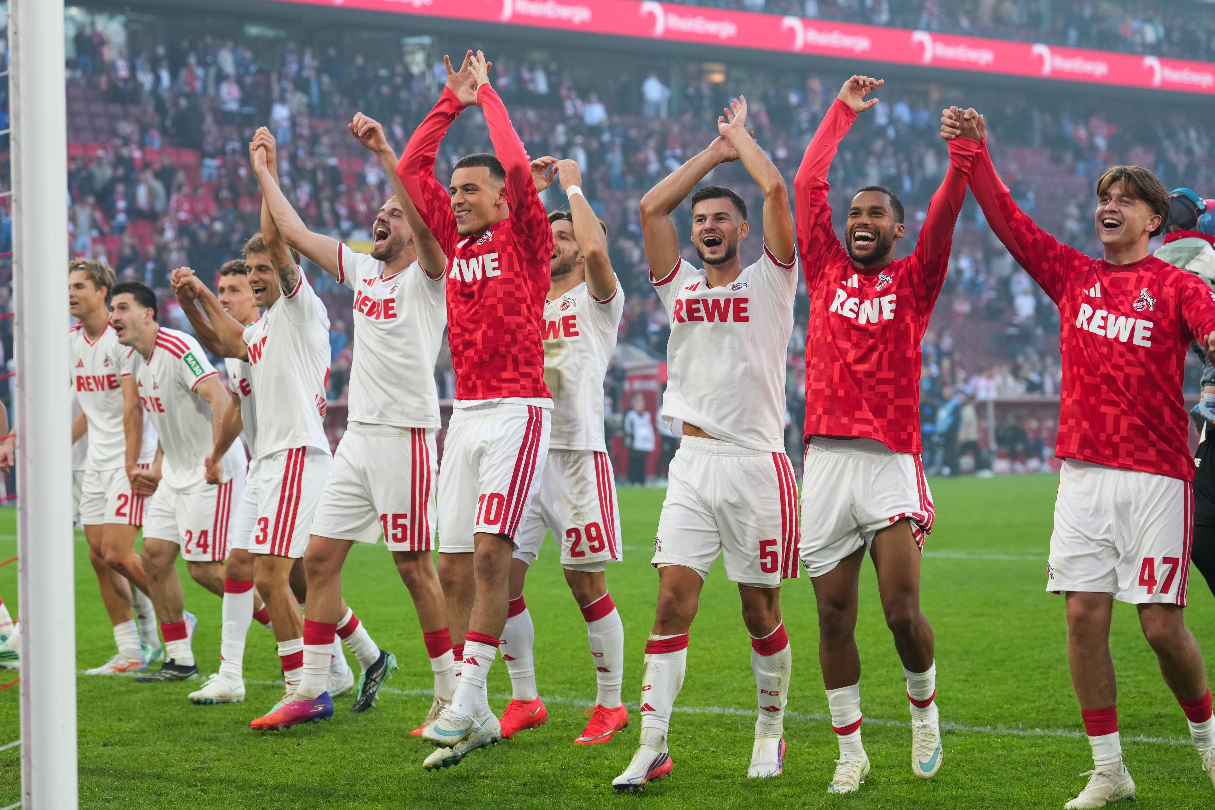 Die FC-Profis jubeln vor der Südkurve mit den Fans.
