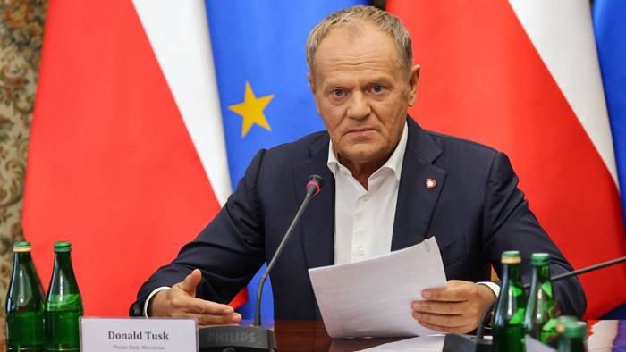 Polens Ministerpräsident Donald Tusk hält ein Dokument während einer Sitzung im Amt des Ministerpräsidenten in Warschau.