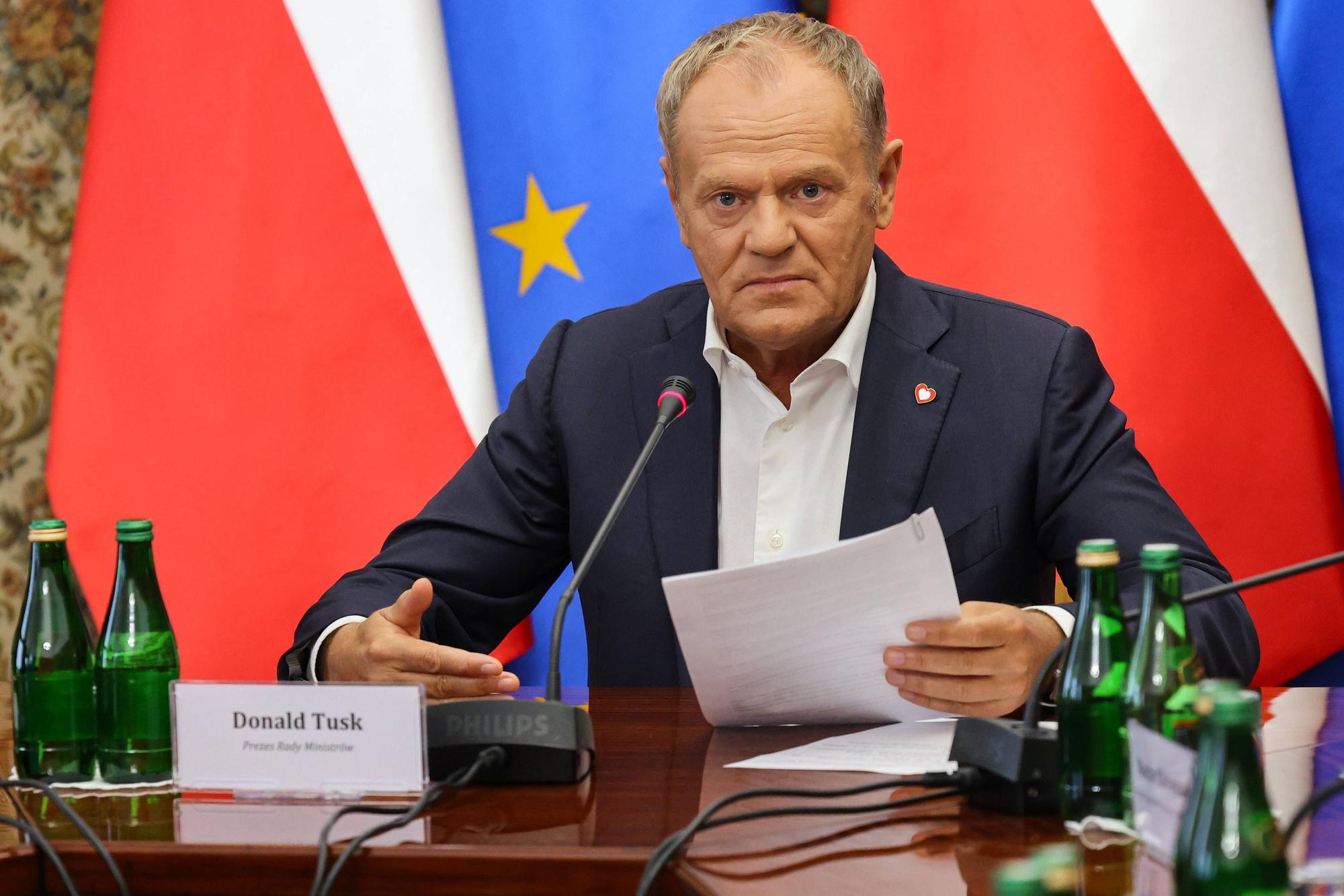 Polens Ministerpräsident Donald Tusk hält ein Dokument während einer Sitzung im Amt des Ministerpräsidenten in Warschau.