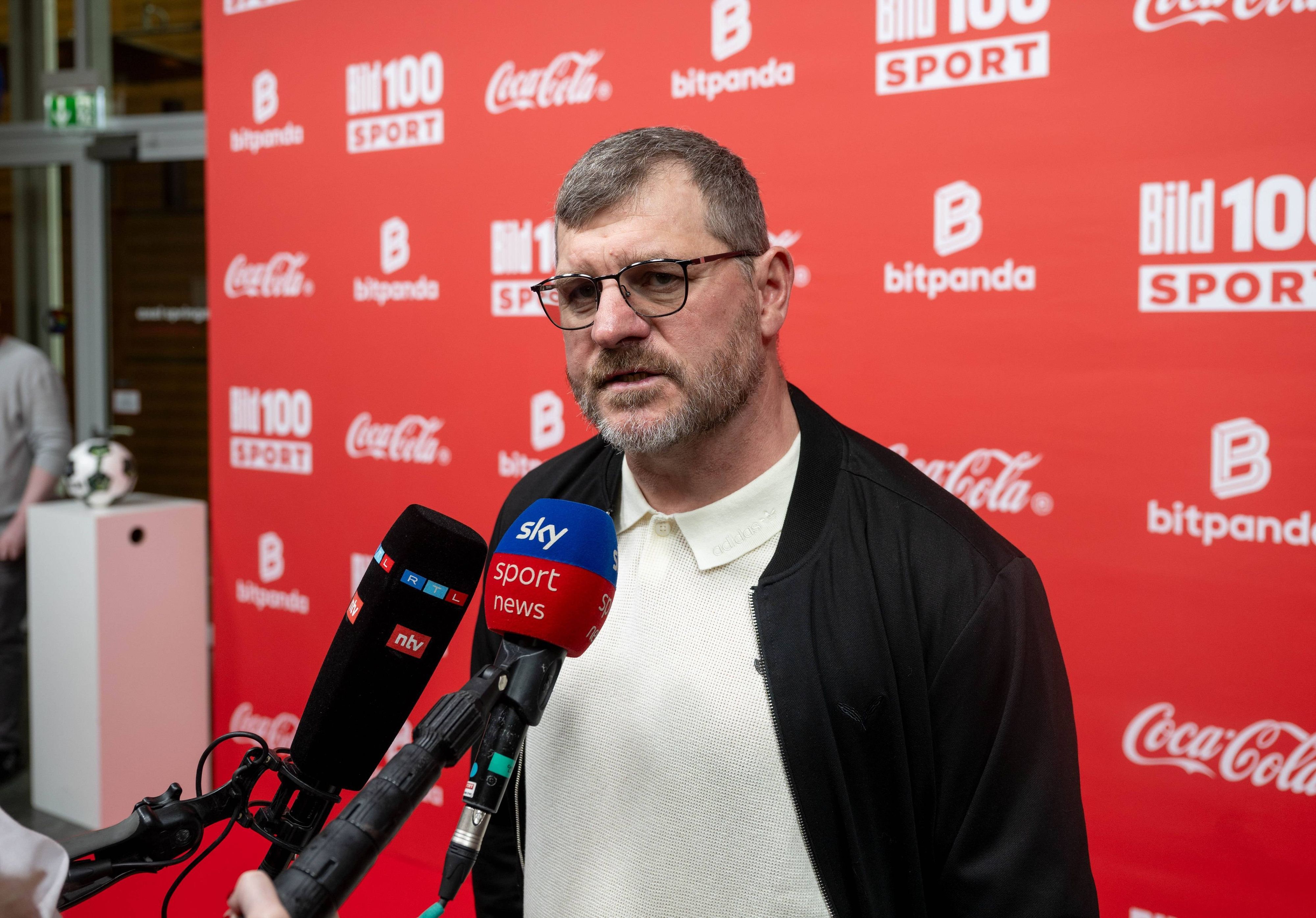 Steffen Baumgart spricht in Mikrofone.