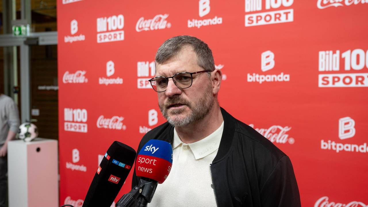 Steffen Baumgart spricht in Mikrofone.