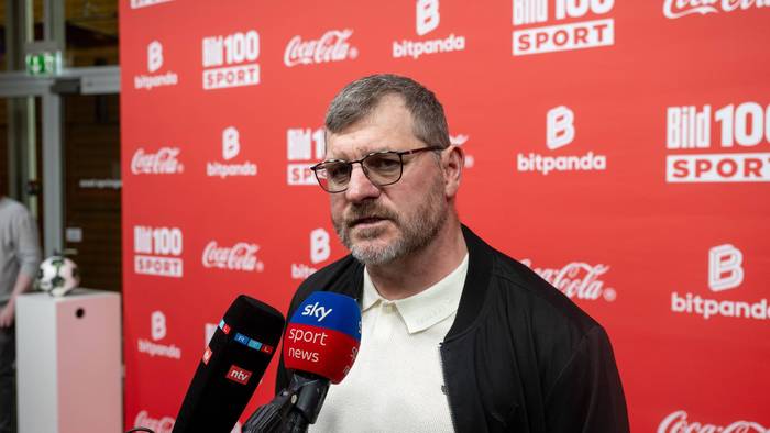 Steffen Baumgart spricht in Mikrofone.
