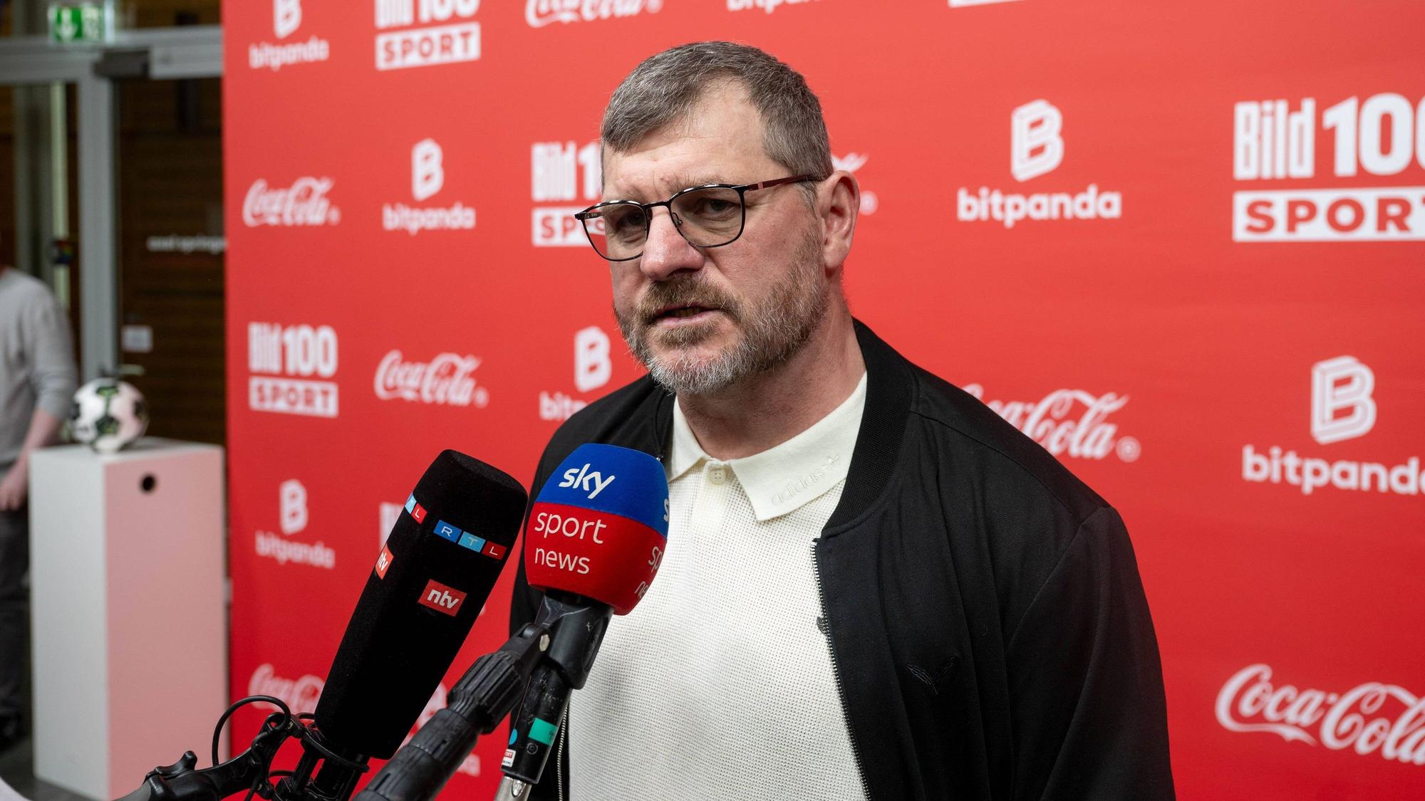 Steffen Baumgart spricht in Mikrofone.