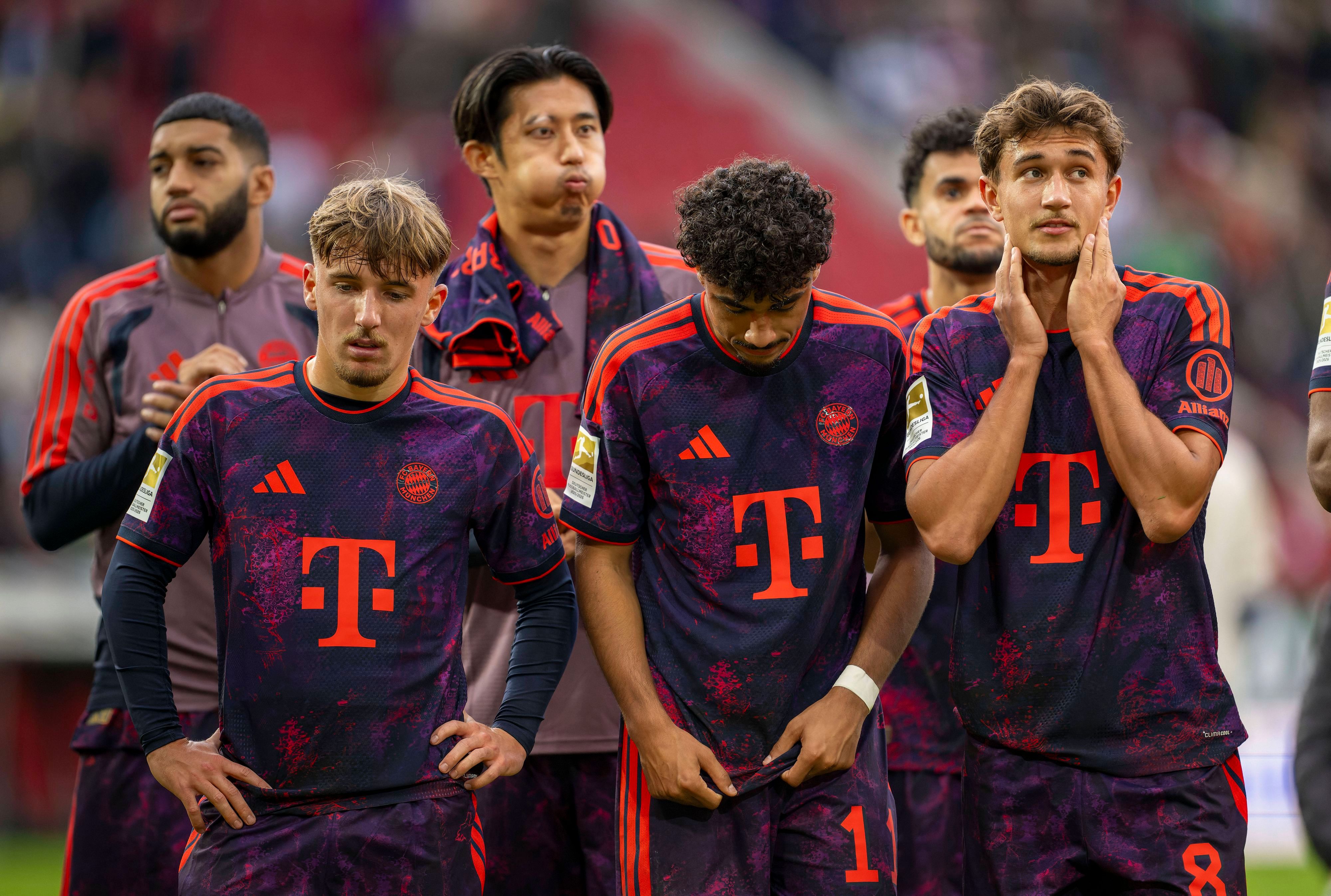 Lennart Karl (v.l.), Nathaniel Brown und Tom Bischof vom FC Bayern stehen nach einem Spiel zusammen.