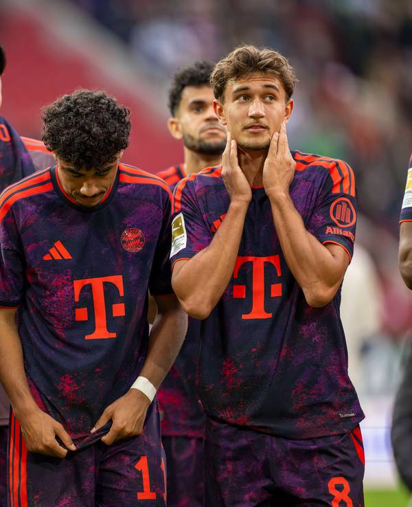 Lennart Karl (v.l.), Nathaniel Brown und Tom Bischof vom FC Bayern stehen nach einem Spiel zusammen.