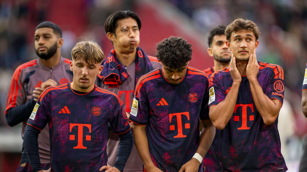 Lennart Karl (v.l.), Nathaniel Brown und Tom Bischof vom FC Bayern stehen nach einem Spiel zusammen.