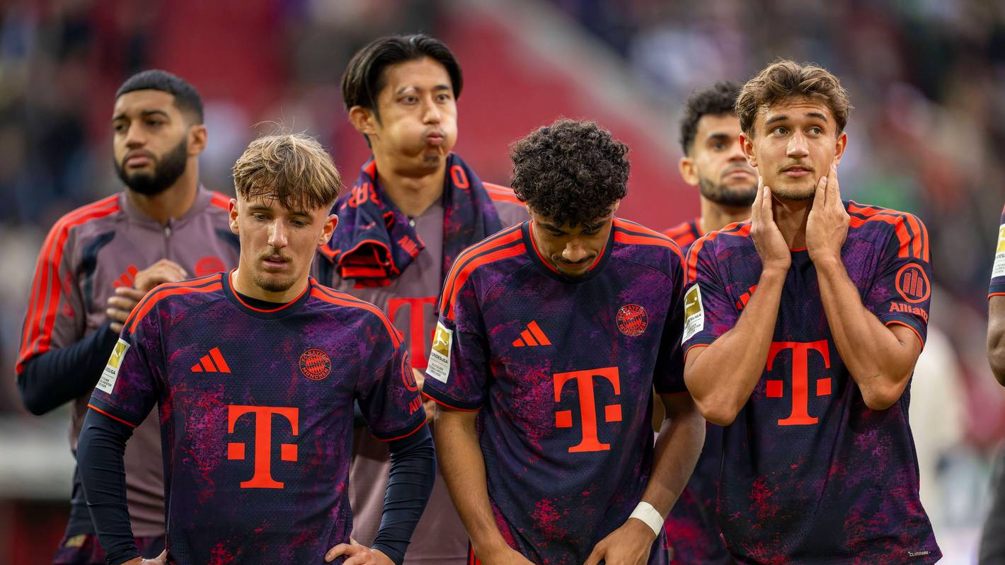 Lennart Karl (v.l.), Nathaniel Brown und Tom Bischof vom FC Bayern stehen nach einem Spiel zusammen.