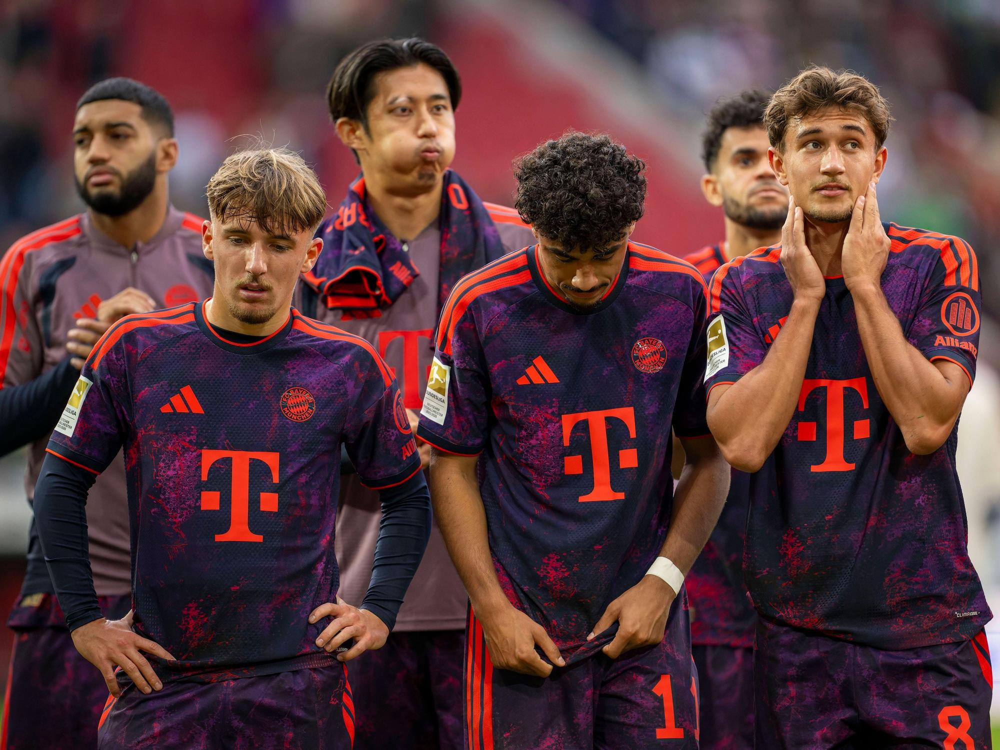 Lennart Karl (v.l.), Nathaniel Brown und Tom Bischof vom FC Bayern stehen nach einem Spiel zusammen.