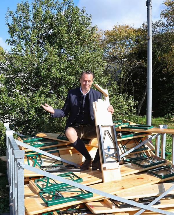 Lukas Wachten sitzt auf den zerbrochenen Bänken der Royal Wiesn.
