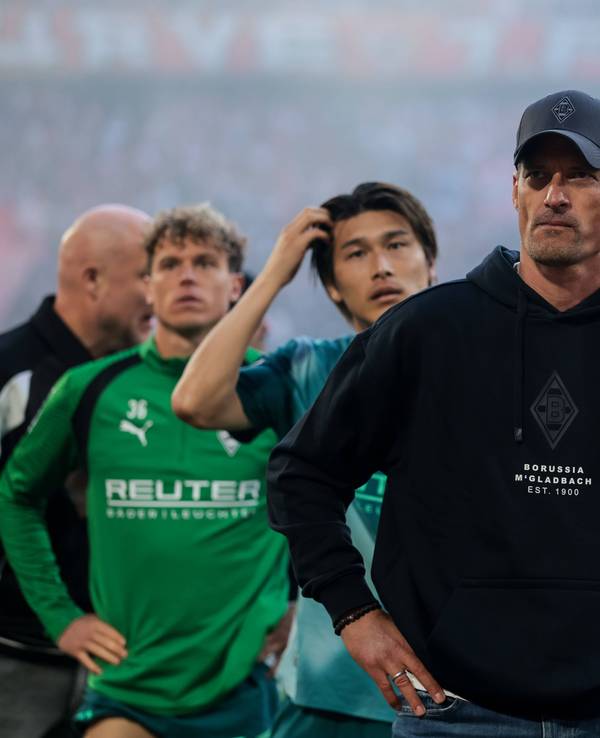 Alexander Blessin steht mit seinen Spielern vor dem Gästeblock.