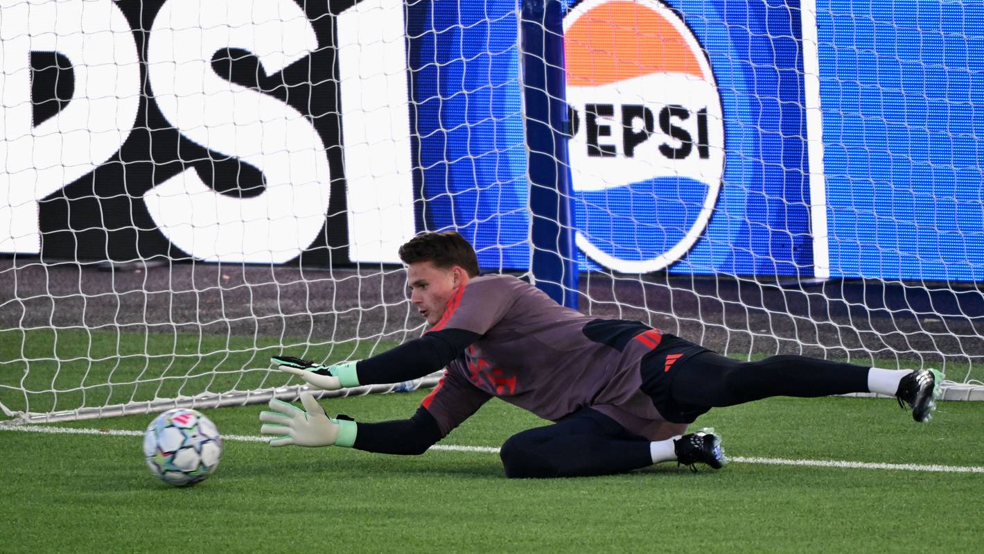 Jonas Urbig hält einen Ball im Training.