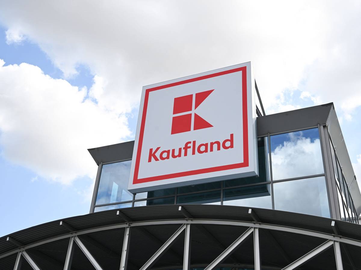 Ein Logo des Lebensmitteländlers Kaufland hängt an einem Haus.