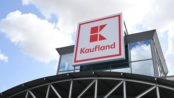 Ein Logo des Lebensmitteländlers Kaufland hängt an einem Haus.