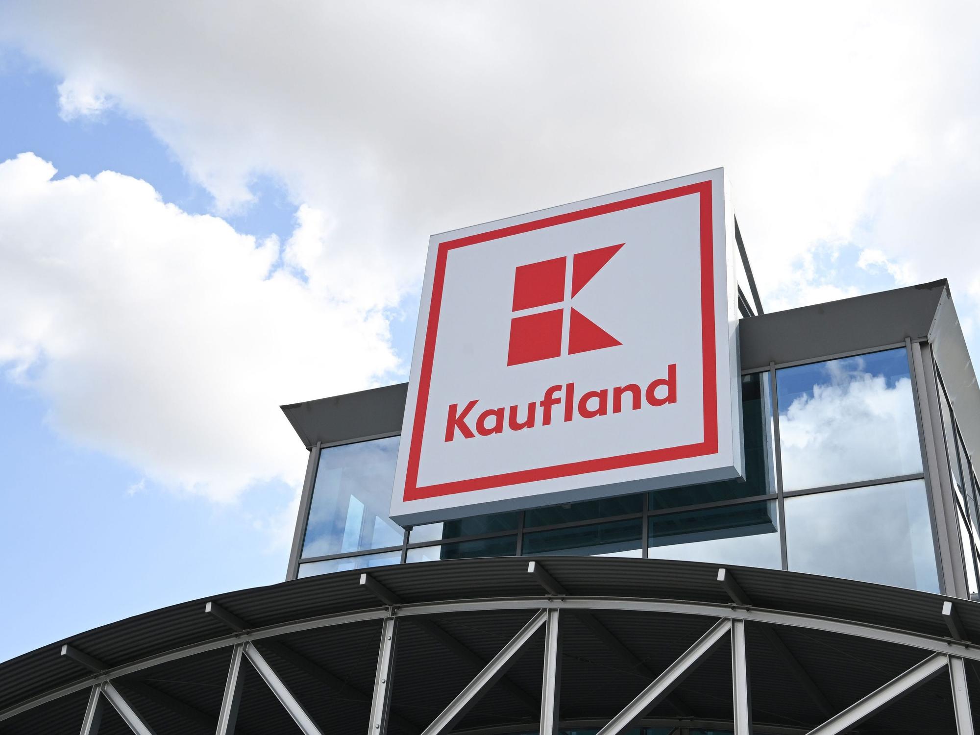 Ein Logo des Lebensmitteländlers Kaufland hängt an einem Haus.