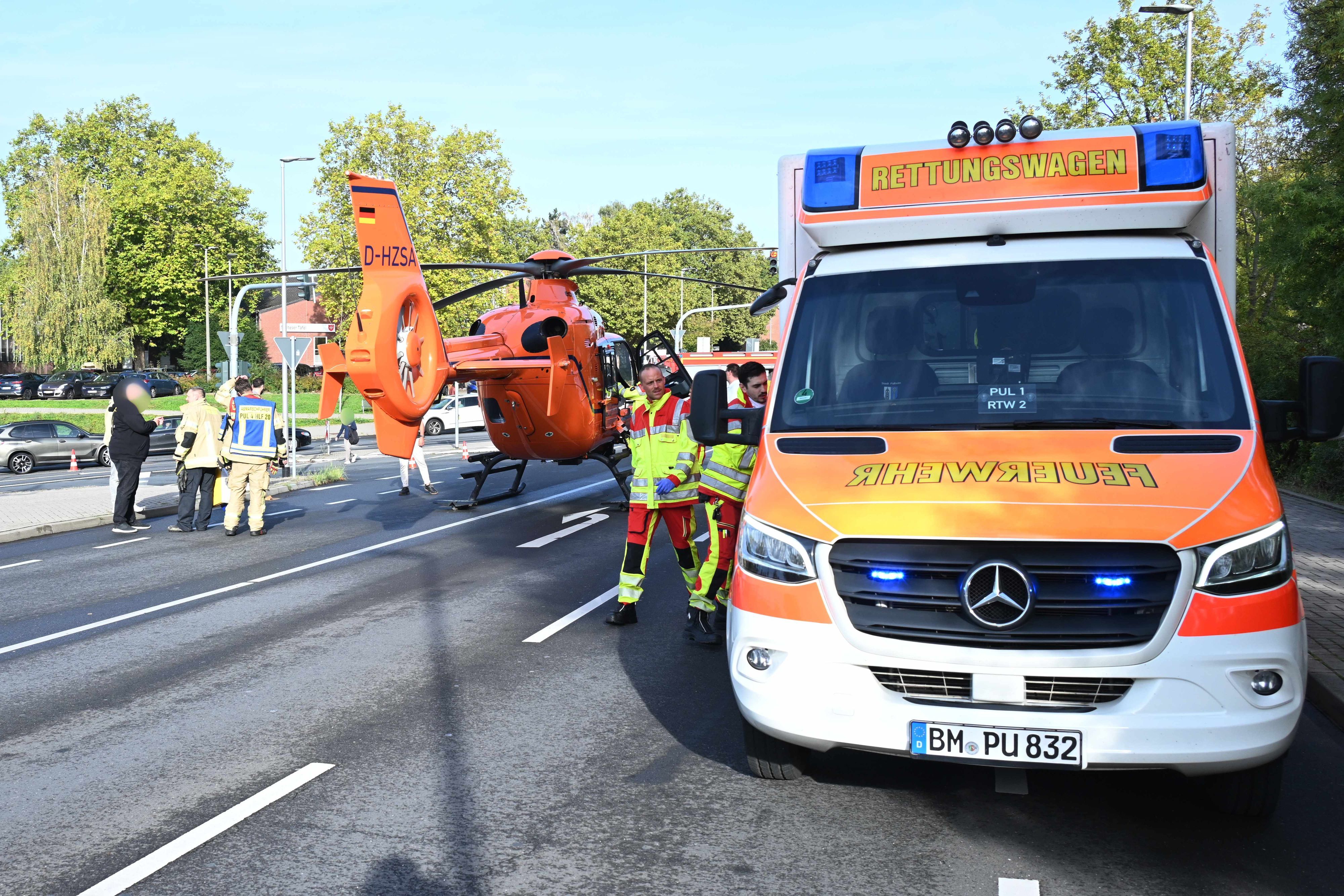 Ein Rettungshubschrauber ist auf einer Straße neben einem Rettungswagen gelandet.