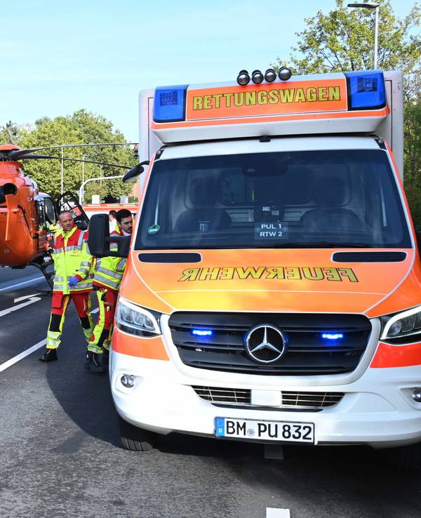 Ein Rettungshubschrauber ist auf einer Straße neben einem Rettungswagen gelandet.