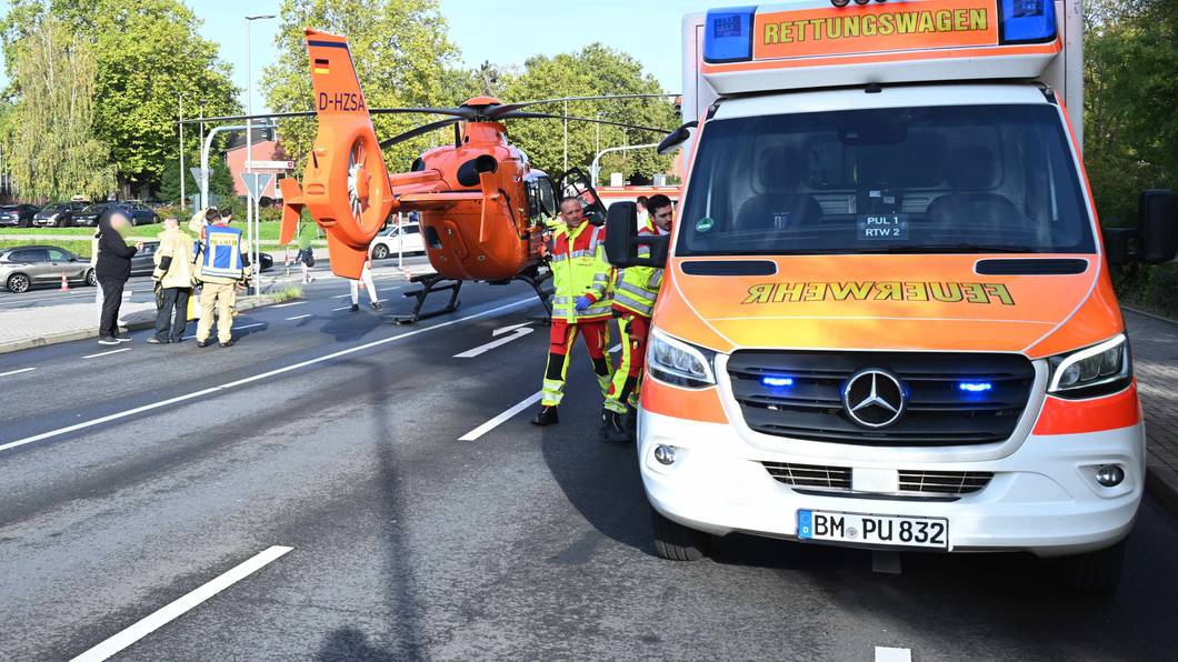 Ein Rettungshubschrauber ist auf einer Straße neben einem Rettungswagen gelandet.