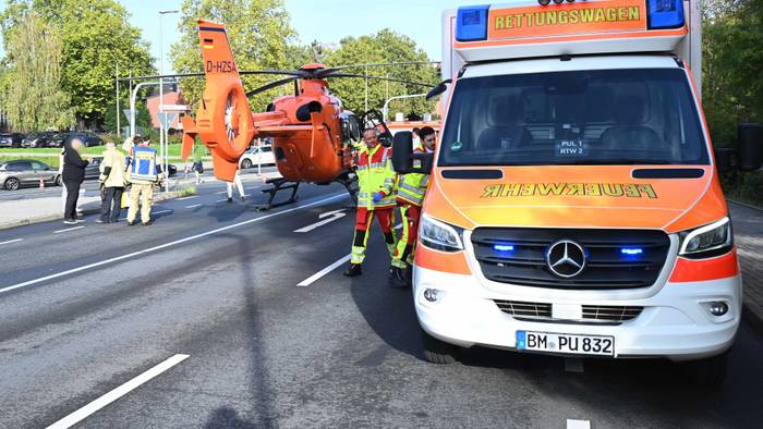 Ein Rettungshubschrauber ist auf einer Straße neben einem Rettungswagen gelandet.