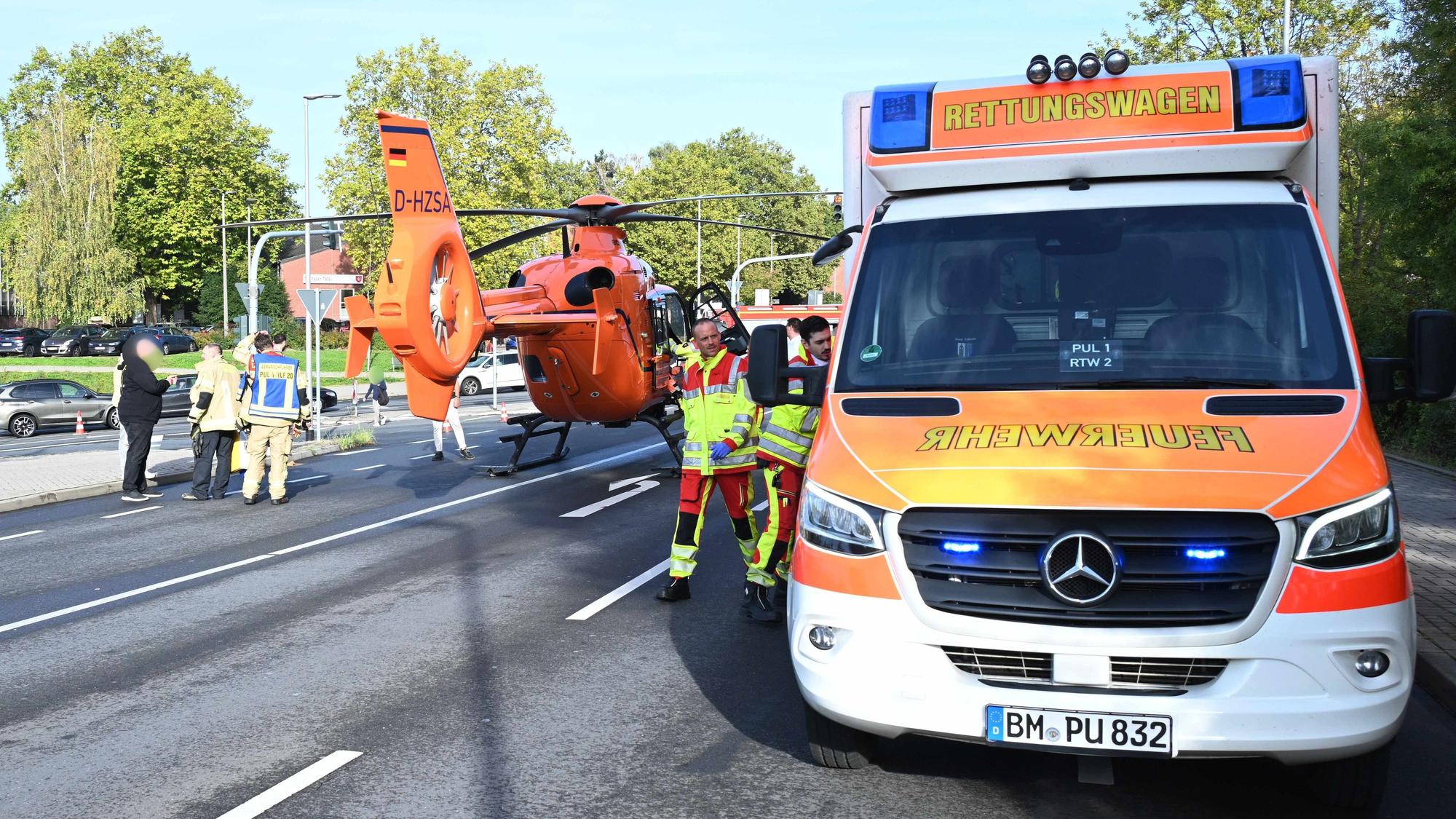 Ein Rettungshubschrauber ist auf einer Straße neben einem Rettungswagen gelandet.