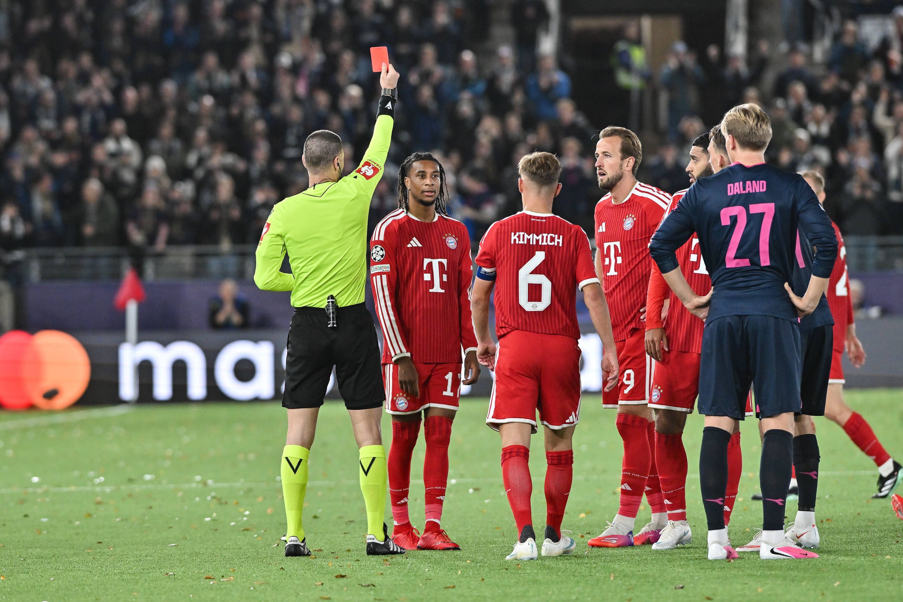 Michael Olise sieht die Gelb-Rote Karte. Joshua Kimmich und Harry Kane stehen daneben.