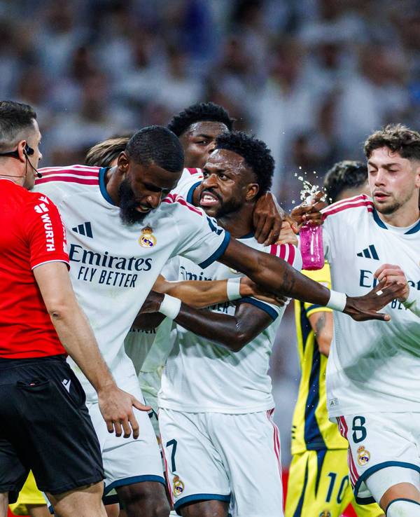 Antonio Rüdiger hält Vinicius Junior vom Schiedsrichter weg und stellt sich mit ausgebreiteten Armen dazwischen.