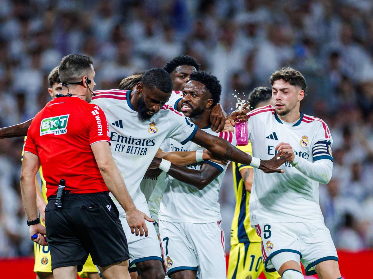 Antonio Rüdiger hält Vinicius Junior vom Schiedsrichter weg und stellt sich mit ausgebreiteten Armen dazwischen.