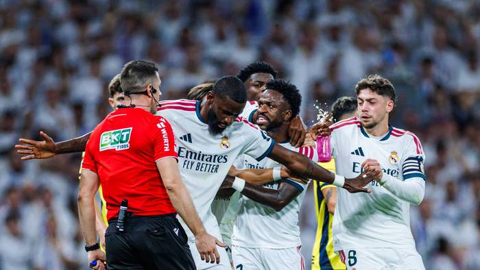 Antonio Rüdiger hält Vinicius Junior vom Schiedsrichter weg und stellt sich mit ausgebreiteten Armen dazwischen.