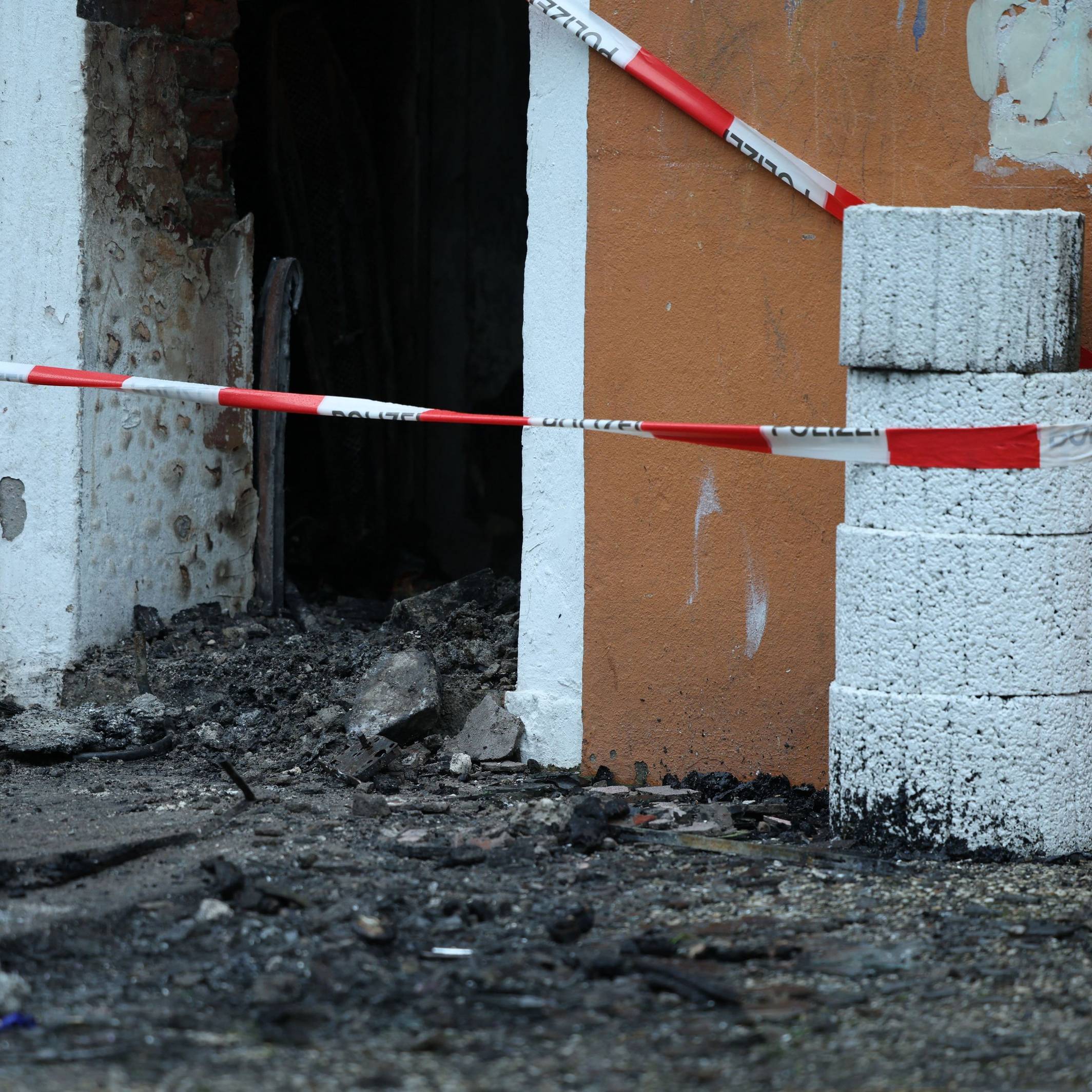 Abgesperrt ist der Zugang zu einem Mehrfamilienhaus nach ein Brand. Dabei sind drei Menschen ums Leben gekommen.