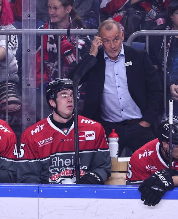 Haie-Cheftrainer Thomas Berglund steht mit seiner Mannschaft an der Seite der Eisfläche.
