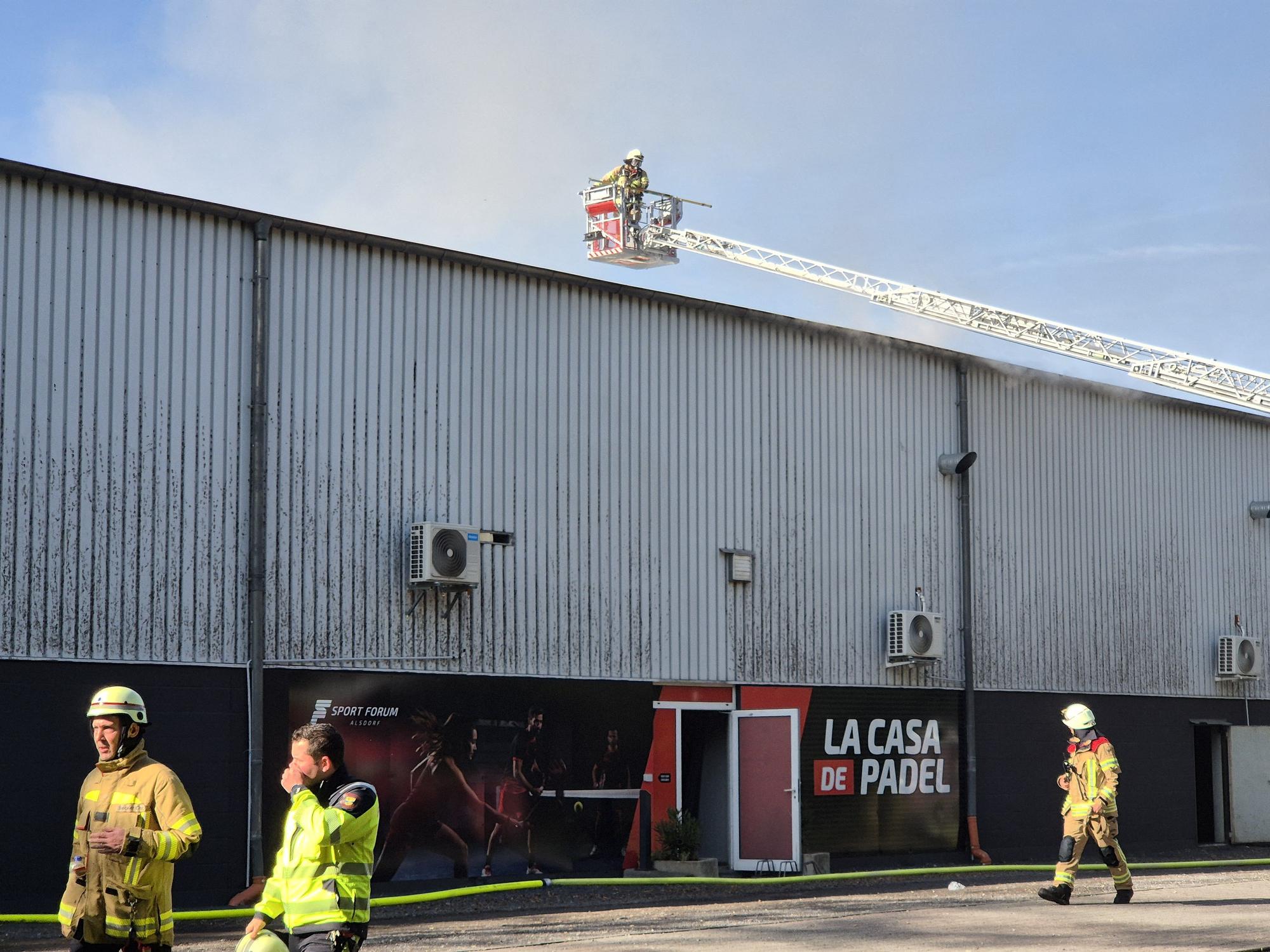 Einsatzkräfte der Feuerwehr löschen einen Brand, der in einem Sportzentrum ausgebrochen ist.