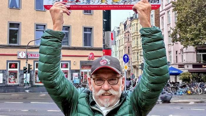 Janus Fröhlich zeigt ein Straßenschild.