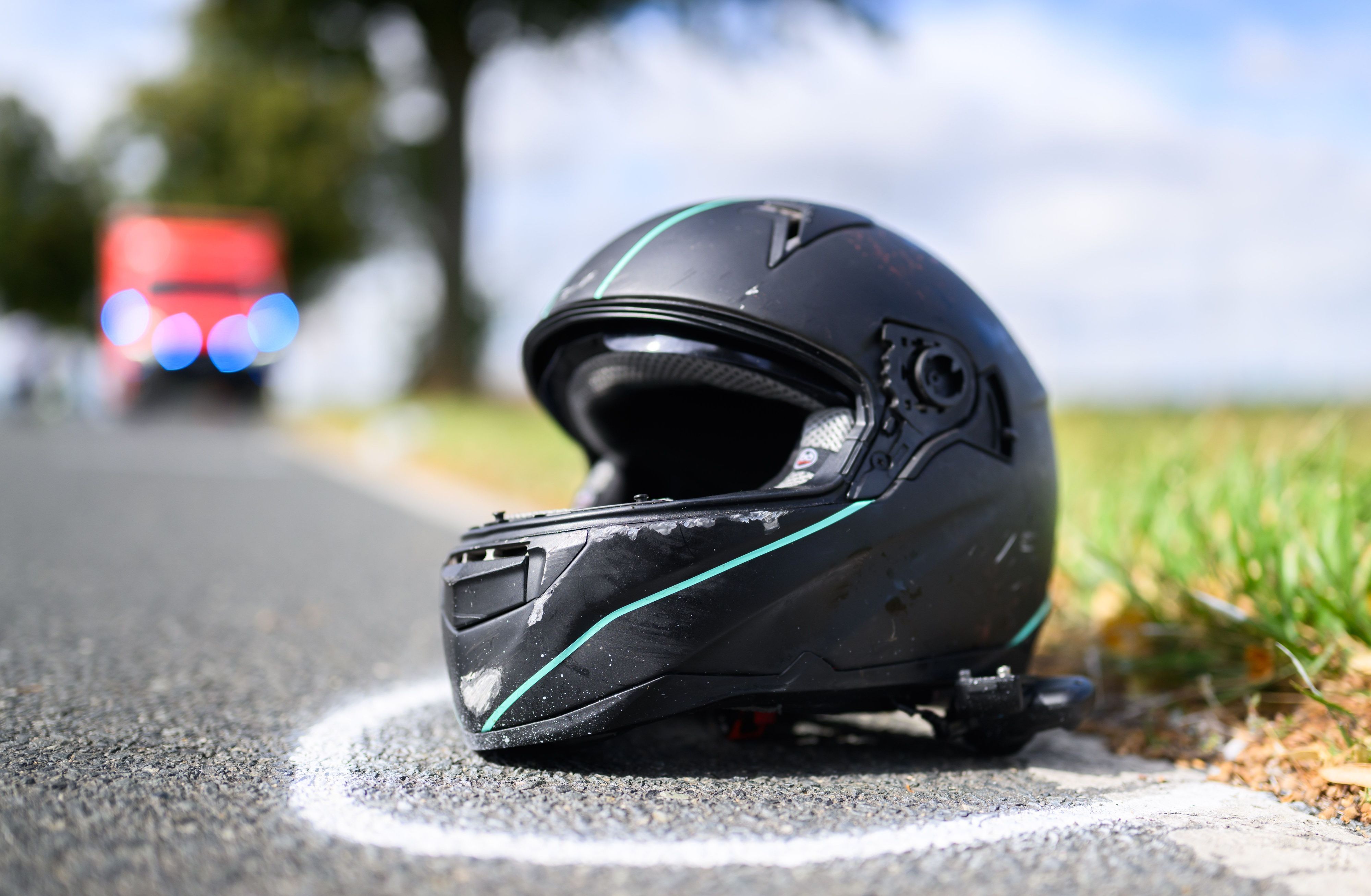 Der Helm eines Motorradfahrers liegt nach einem Unfall auf der Straße.