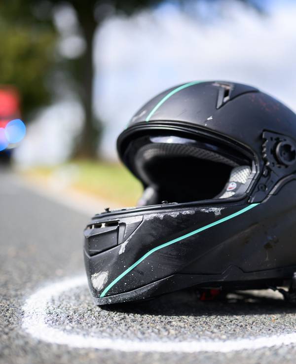Der Helm eines Motorradfahrers liegt nach einem Unfall auf der Straße.
