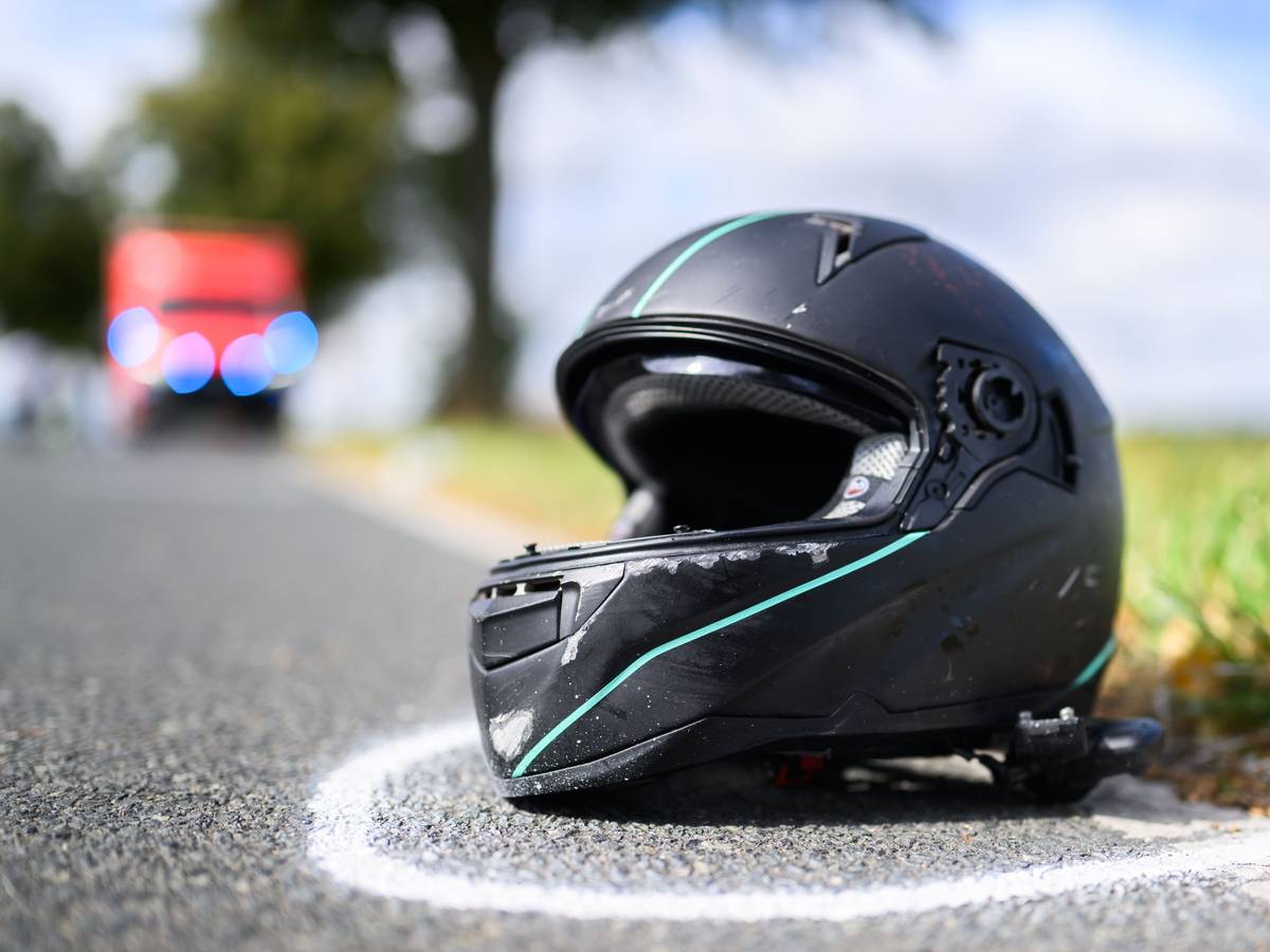 Der Helm eines Motorradfahrers liegt nach einem Unfall auf der Straße.