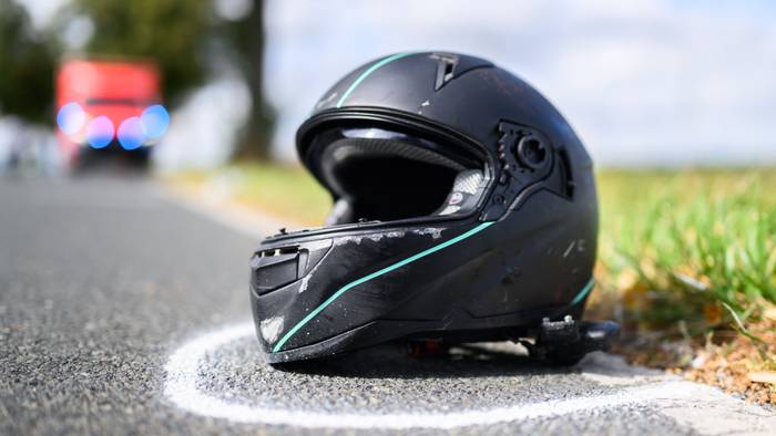Der Helm eines Motorradfahrers liegt nach einem Unfall auf der Straße.