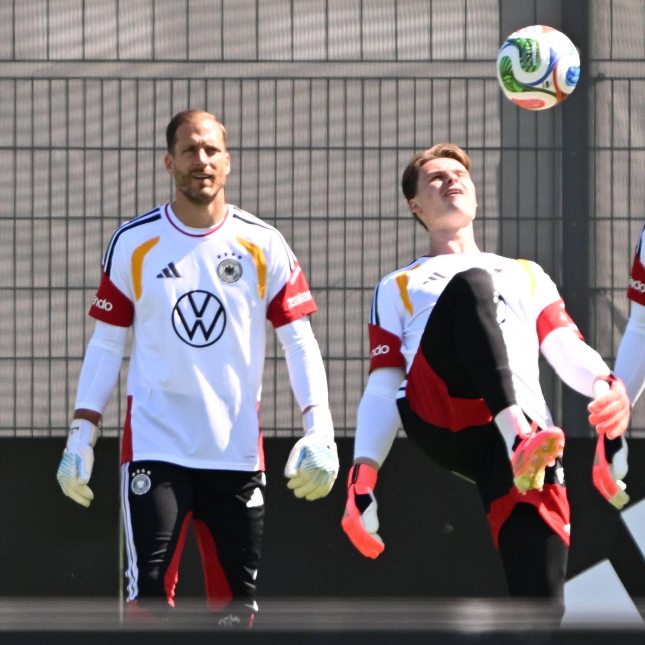 Jonas Urbig hält den Ball mit dem Oberschenkel hoch, Oliver Baumann und Alexander Nübel schauen ihm zu.