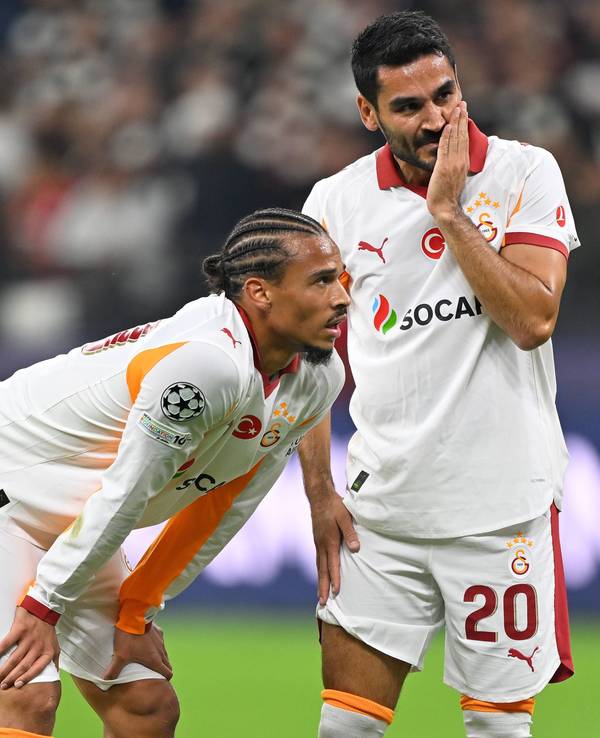 Leroy Sane und Ilkay Gündogan stehen auf dem Spielfeld und überlegen.