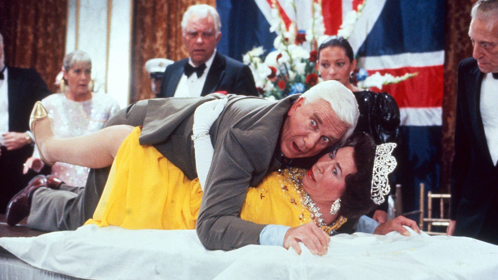 Frank Drebin (Leslie Nielsen) blamiert nicht nur sich selbst, sondern auch die britische Königin.  (Bild: RTLZWEI)