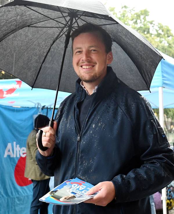 AfD-Politiker Matthias Büschges steht in Köln-Porz im Regen und macht Wahlkampf.