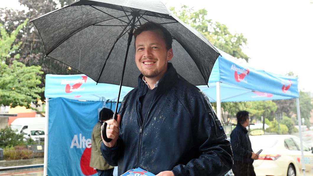 AfD-Politiker Matthias Büschges steht in Köln-Porz im Regen und macht Wahlkampf.