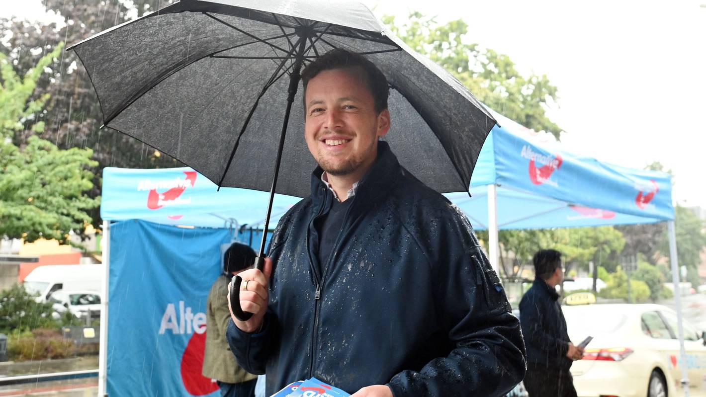 AfD-Politiker Matthias Büschges steht in Köln-Porz im Regen und macht Wahlkampf.