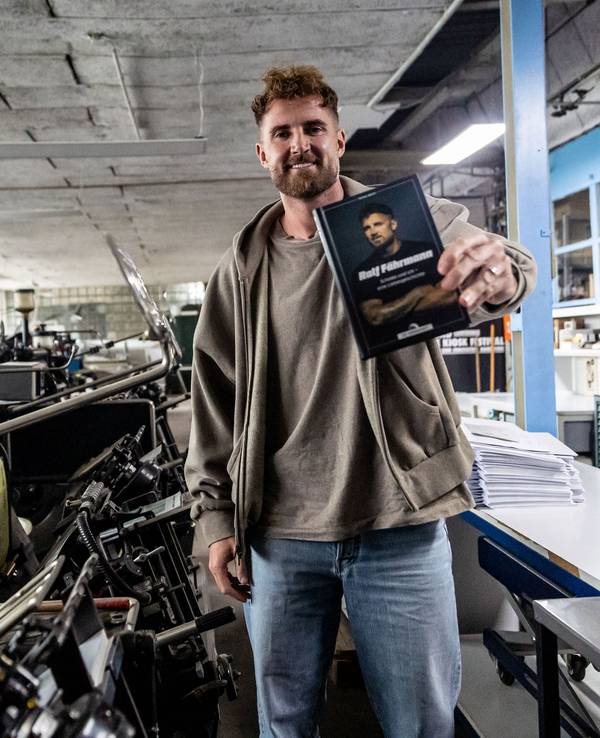 Der ehemalige Schalke-Torwart Ralf Fährmann hält sein Buch in der Hand.